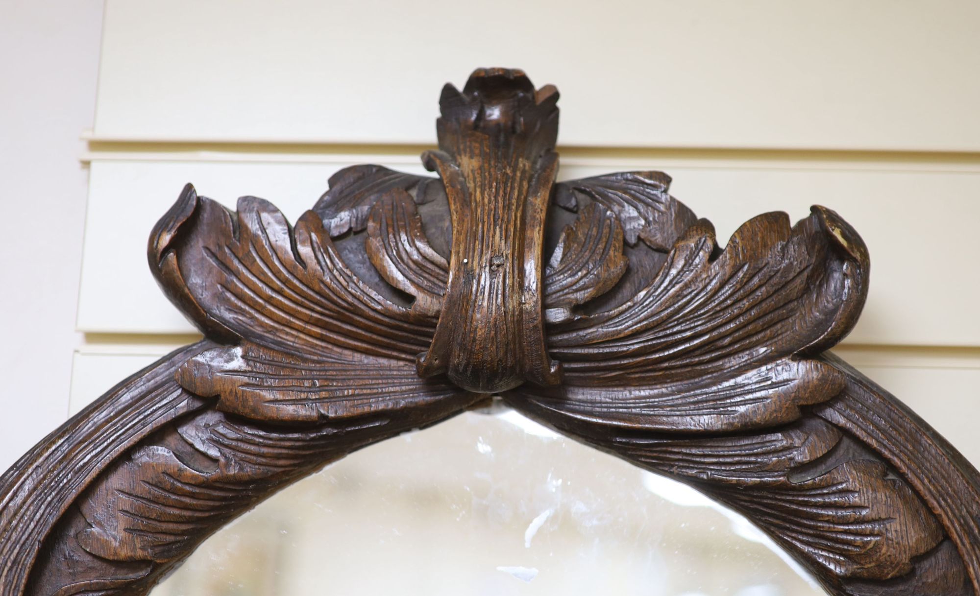 An early 19th century oval carved wall mirror